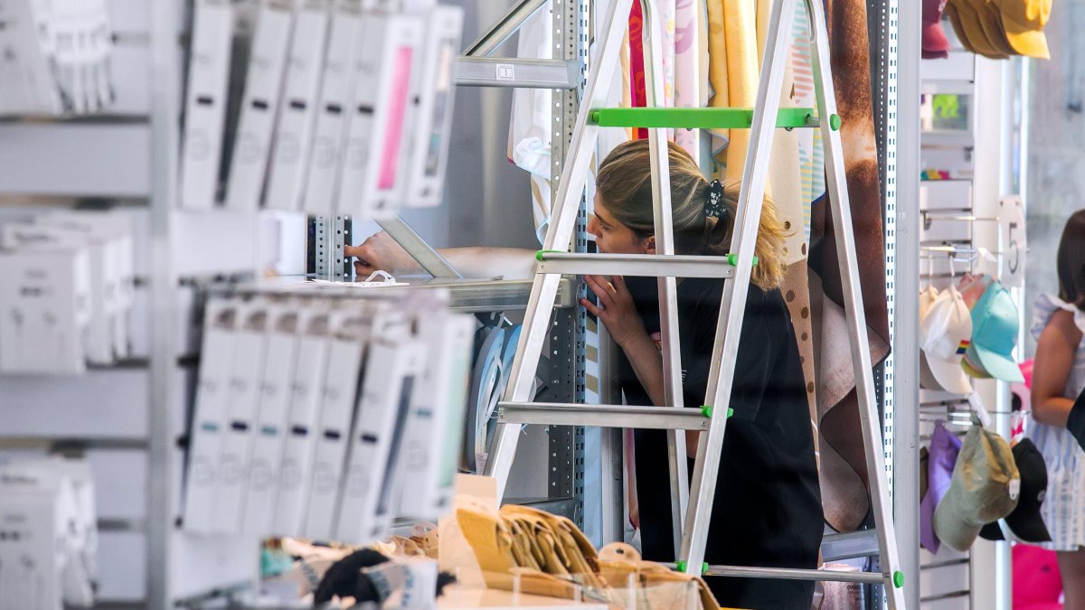 Una dependienta colocando estanterías.