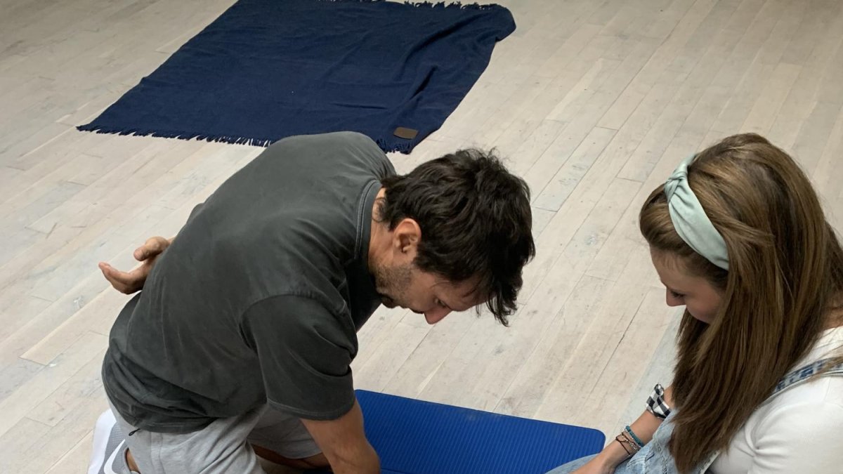 Dos personas practican una RCP a un maniquí en un curso de primeros auxilios.