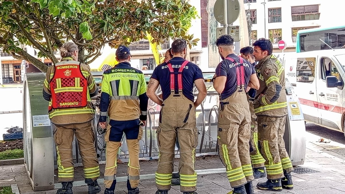 Bomberos revisan el mecanismo de apertura de un aparcabicis cubierto en la plaza de España.