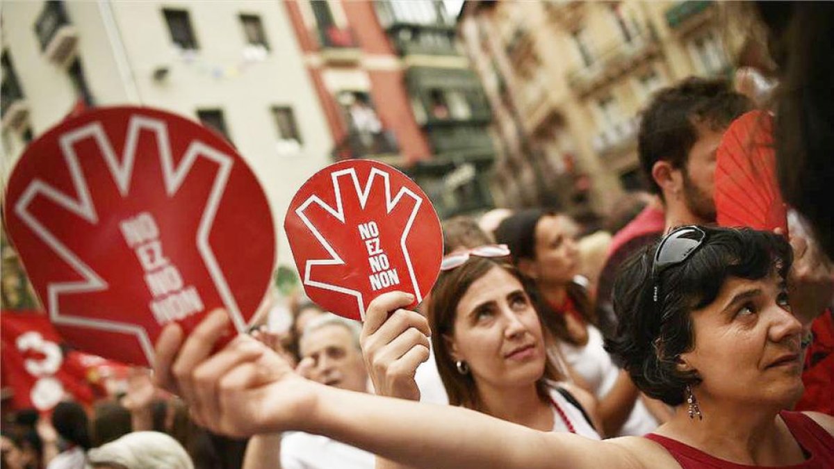 Unas mujeres muestran el símbolo de la campaña contra las agresiones sexistas en Sanfermines durante la manifestación ciudadana.-AP