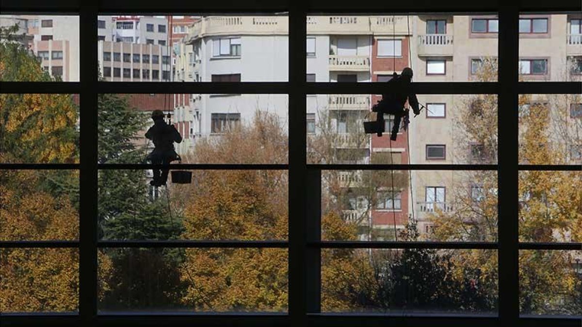 Imagen de dos personas trabajando en una fachada.-RAÚL G. OCHOA