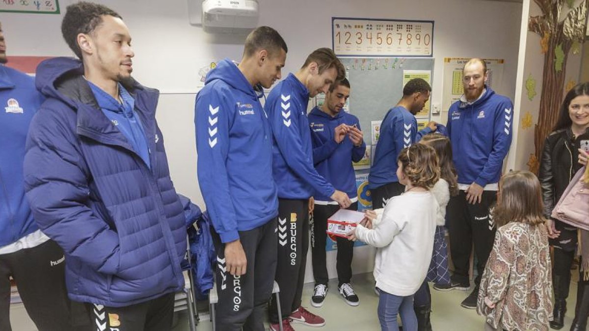 Los jugadores del San Pablo reparten juguetes en su visita al Hospital Universitario de Burgos, ayer.-SANTI OTERO