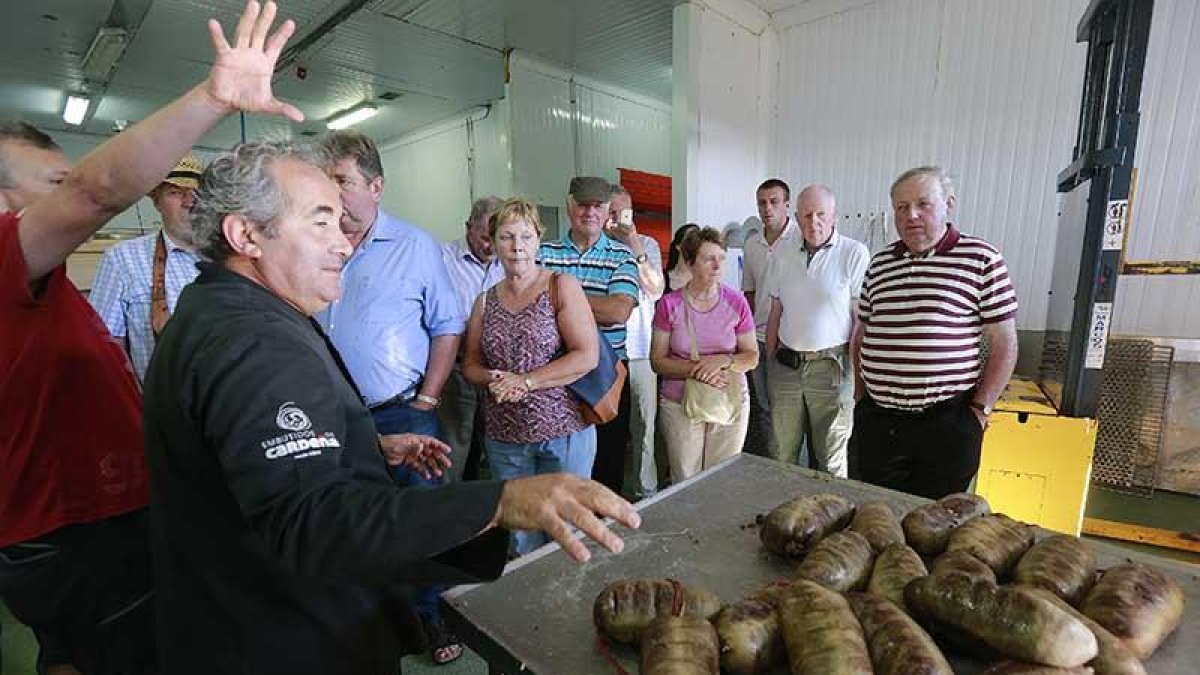 Roberto da Silva explica a unos visitantes el proceso de elaboración de la morcilla. ECB
