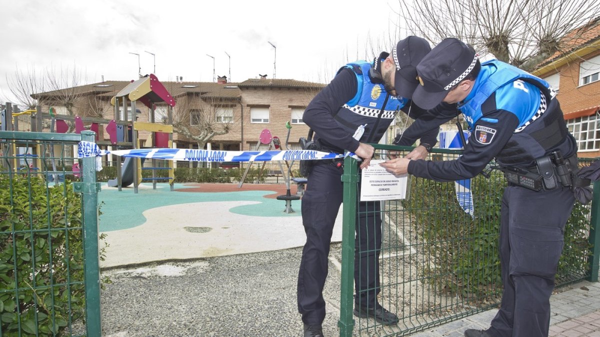 Dos agentes de Policía Local clausuran un parque infantil en Burgos por el coronavirus. / ISRAEL L. MURILLO