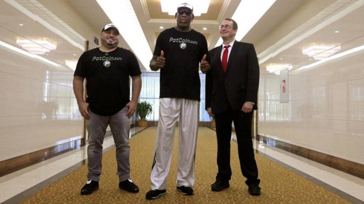 Dennis Rodman (centro), a su llegada al aeropuerto de Pionyang.-AP / KIM HWANG HYON
