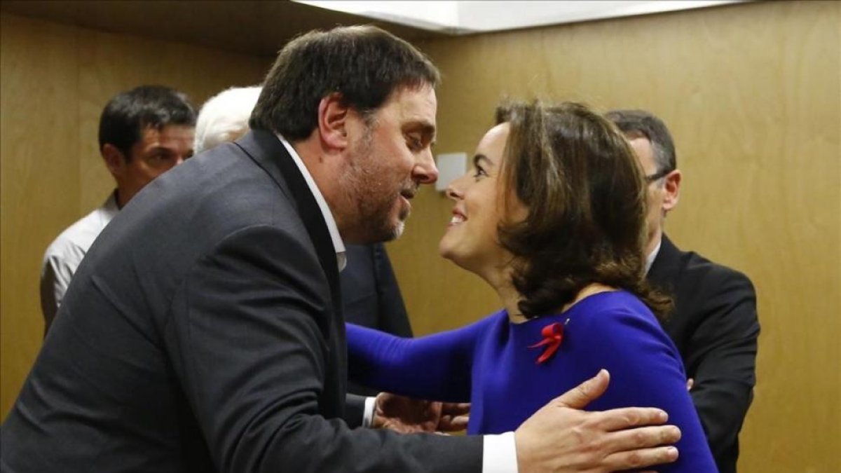 Santamaría y Junqueras se saludan antes de empezar la reunión del Consejo de Política Fiscal y Financiera.-AGUSTÍN CATALÁN