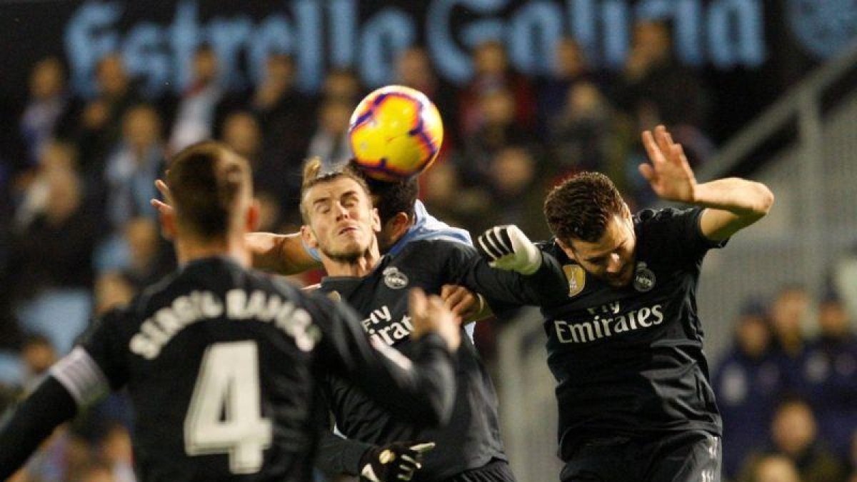 Nacho (d) salta a remtar un balón en el partido ante el Celta.-EFE