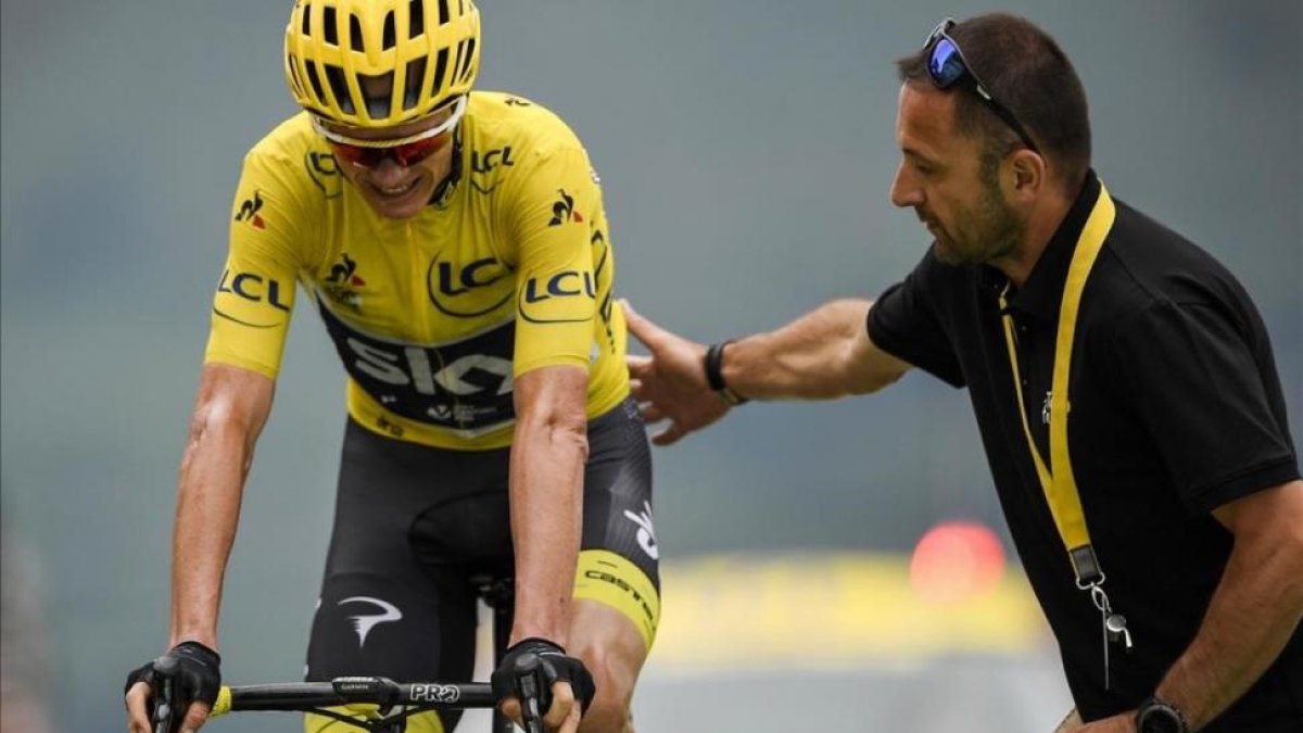 Un empleado del Tour ayuda a Chris Froome, tras cruzar la meta de Peyragudes.-AFP / LIONEL BONAVENTURE