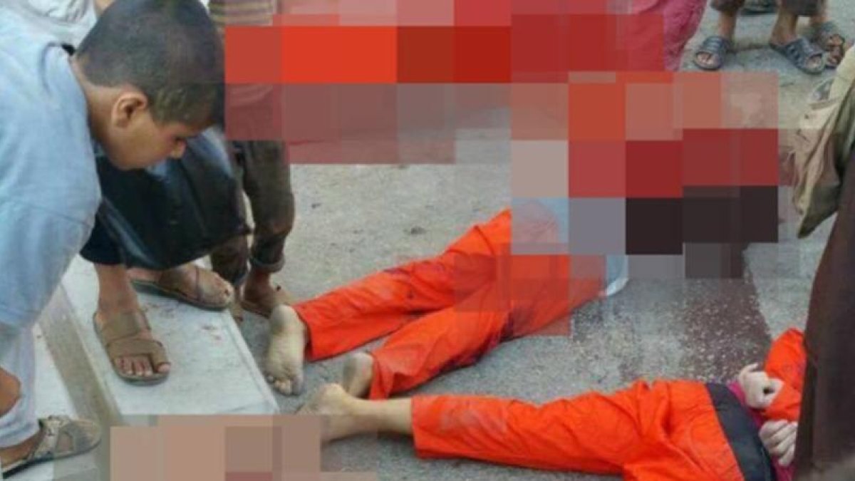 Un niño contempla el cuerpo sin vida de los futbolistas decapitados en Raqqa.-