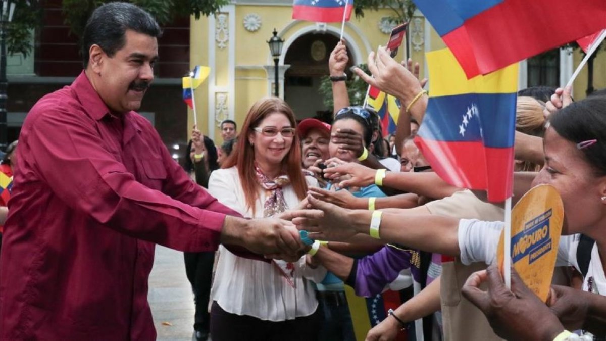 Maduro y su esposa, Cilia Flores, saludan a sus seguidores en un acto en Caracas, el 25 de enero.-/ EFE