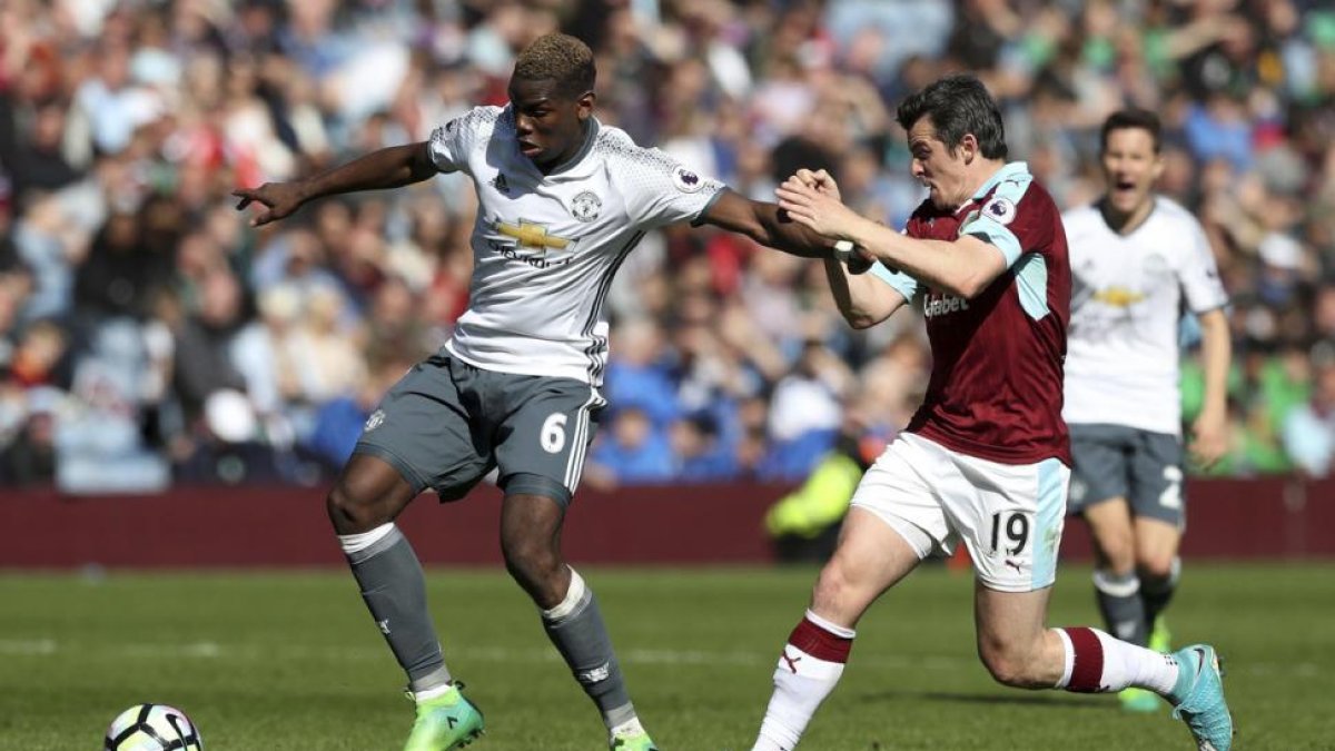 Joey Barton, a la derecha, peleando por un balón con Paul Pogba, del Manchester United.-MARTIN RICKETT / AP