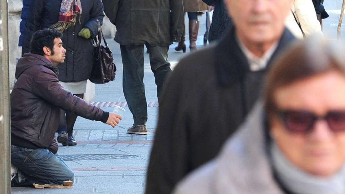 Un hombre pide limosna en una calle de la capital burgalesa.-ISRAEL L. MURILLO