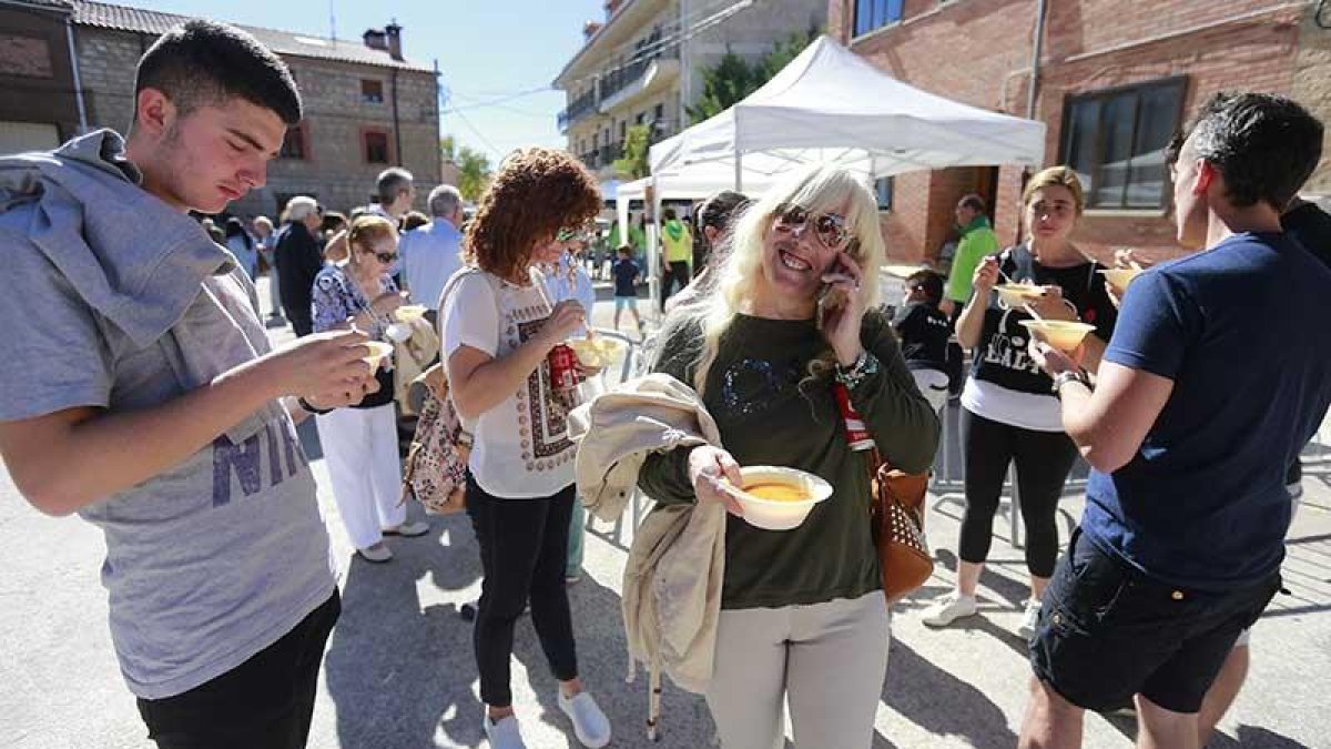 Varios asistentes disfrutan de uno de los guisos que las peñas participantes ofrecían durante la feria.-RAÚL G. OCHOA