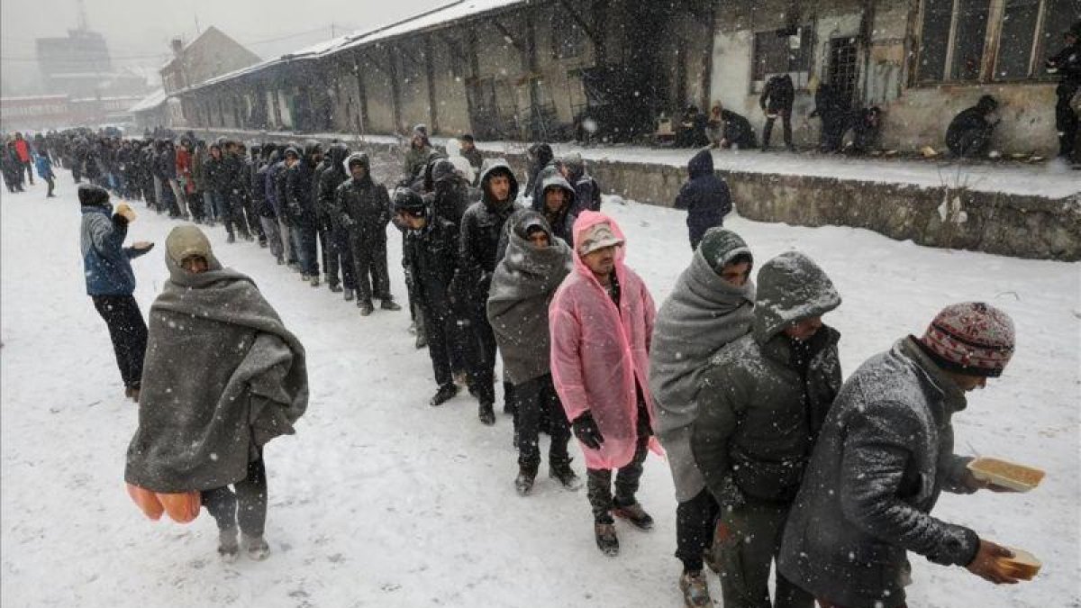 Inmigrantes reciben comida en el exterior de un almacén aduanero abandonado en Belgrado, Serbia.-REUTERS / MARKO DJURICA