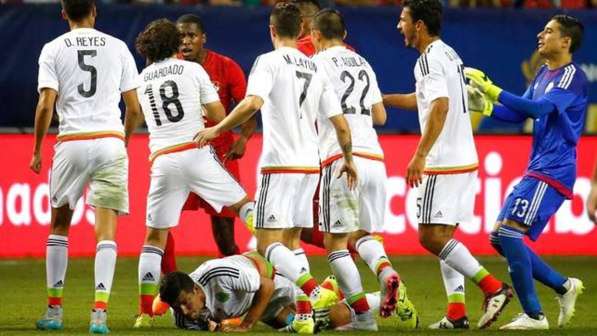 Los jugadores de México rodean al panameño Tejada tras recibir la tarjeta roja en la semifinal de la Copa de Oro, en Atlanta.-Foto: AFP / KEVIN C. COX