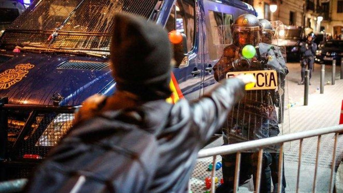 Un manifestante lanza una pelota a un policía, este sábado junto a la jefatura de Via Laietana-