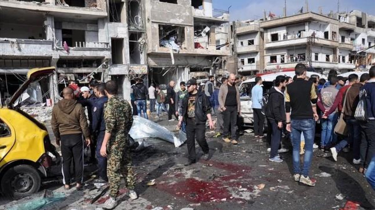 Lugar donde han estallado dos coches bomba en la ciudad de Homs.-AFP