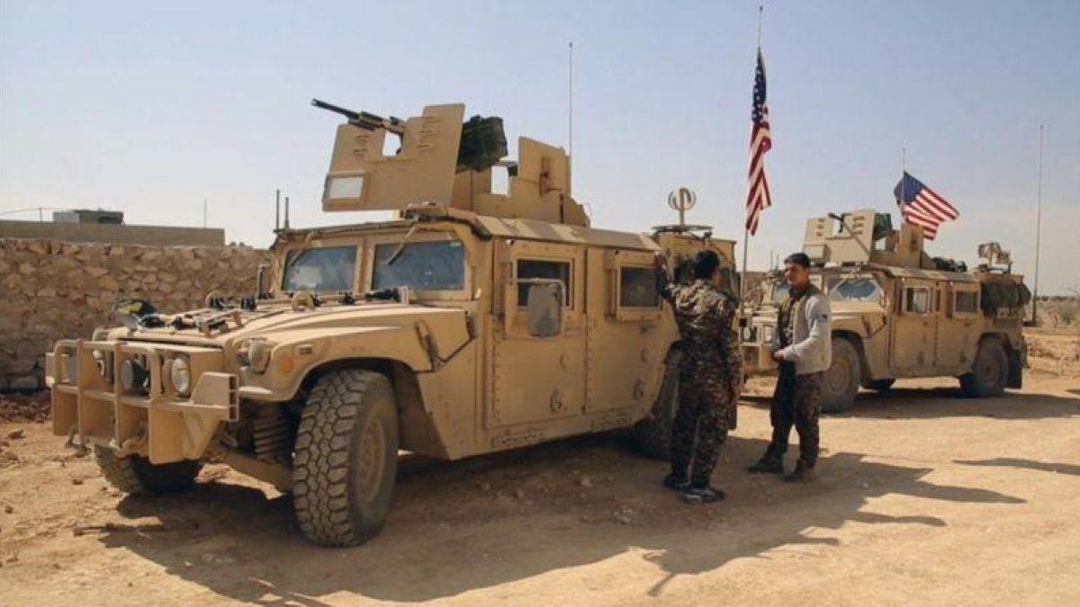 Combatientes de las Fuerzas Democráticas Sirias junto a vehículos militares de EEUU en las afueras de Manbij, en la provincia de Alepo, el 7 de marzo.-AP