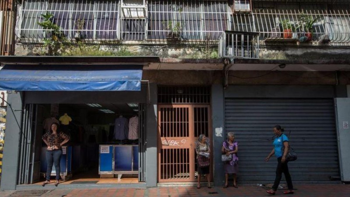 Un comercio abierto y otro cerrado en una calle de Caracas.-EFE / MIGUEL GUTIÉRREZ