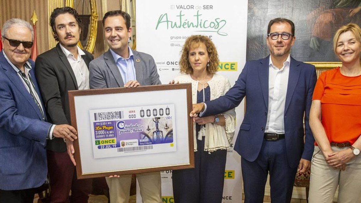 De la Rosa sostiene el cupón con la imagen del reloj ‘El Morito’ acompañado de Pérez y otros miembros de la ONCE.-SANTI OTERO