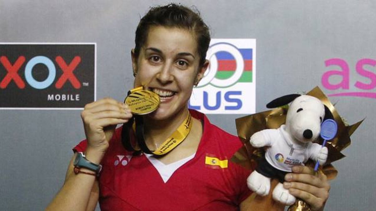 Carolina Marín 'muerde' la medalla de oro que la acredita como ganadora del Abierto de Malasia de bádminton.-Foto: AP / JOSHUA PAUL