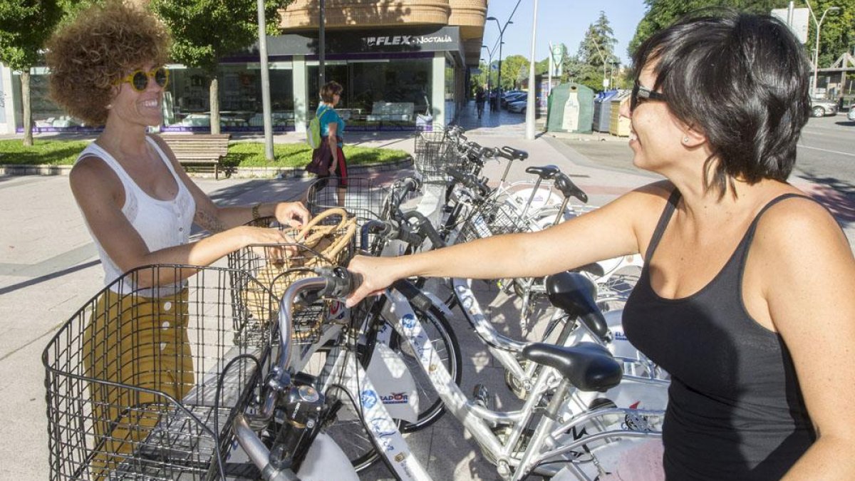 Dos mujeres dejan unas bicicletas en la bancada de avenida Reyes Católicos, cercana al edificio de Juzgados.-ISRAEL L. MURILLO