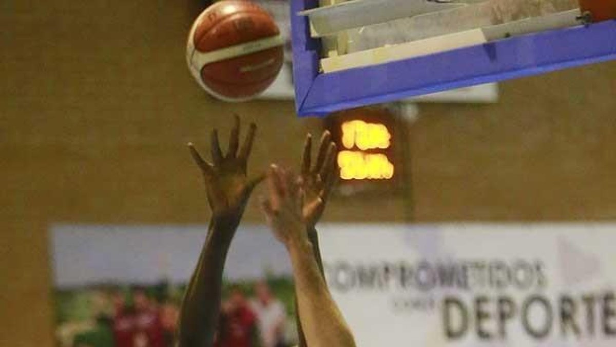 Gana Ndiaye lanza a canasta por encima de Txomin López (Grupo De Santiago).-RAÚL OCHOA