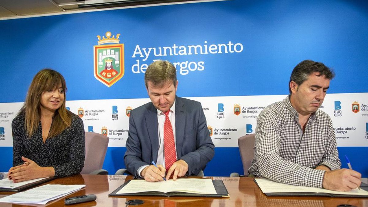 Los alcaldes de Burgos y Cardeñajimeno firman el convenio ante la mirada de la edil Carolina Blasco.-SANTI OTERO