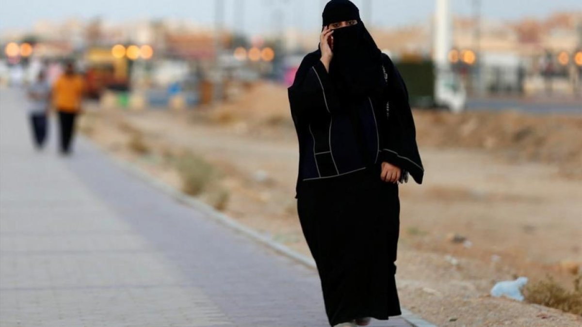 Una mujer saudi habla por teléfono mientras camina por una calle de Riad-REUTERS / FAISAL AL NASSER