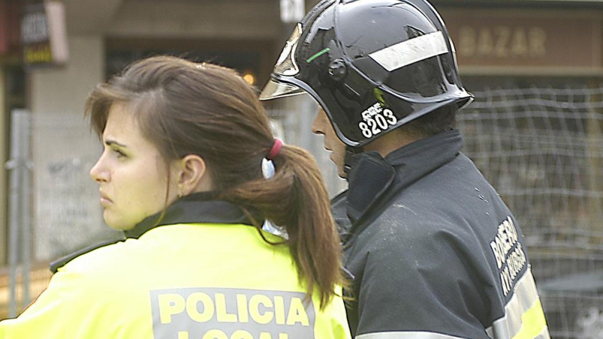 Una policia local y un bombero, durante una intervención.