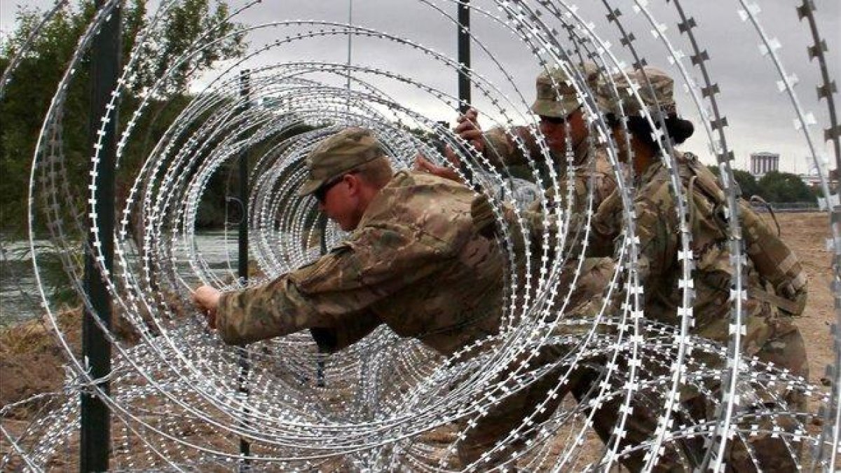 Soldados estadounidenses instalan concertinas en Laredo, Texas.-AFP / THOMAS WATKINS