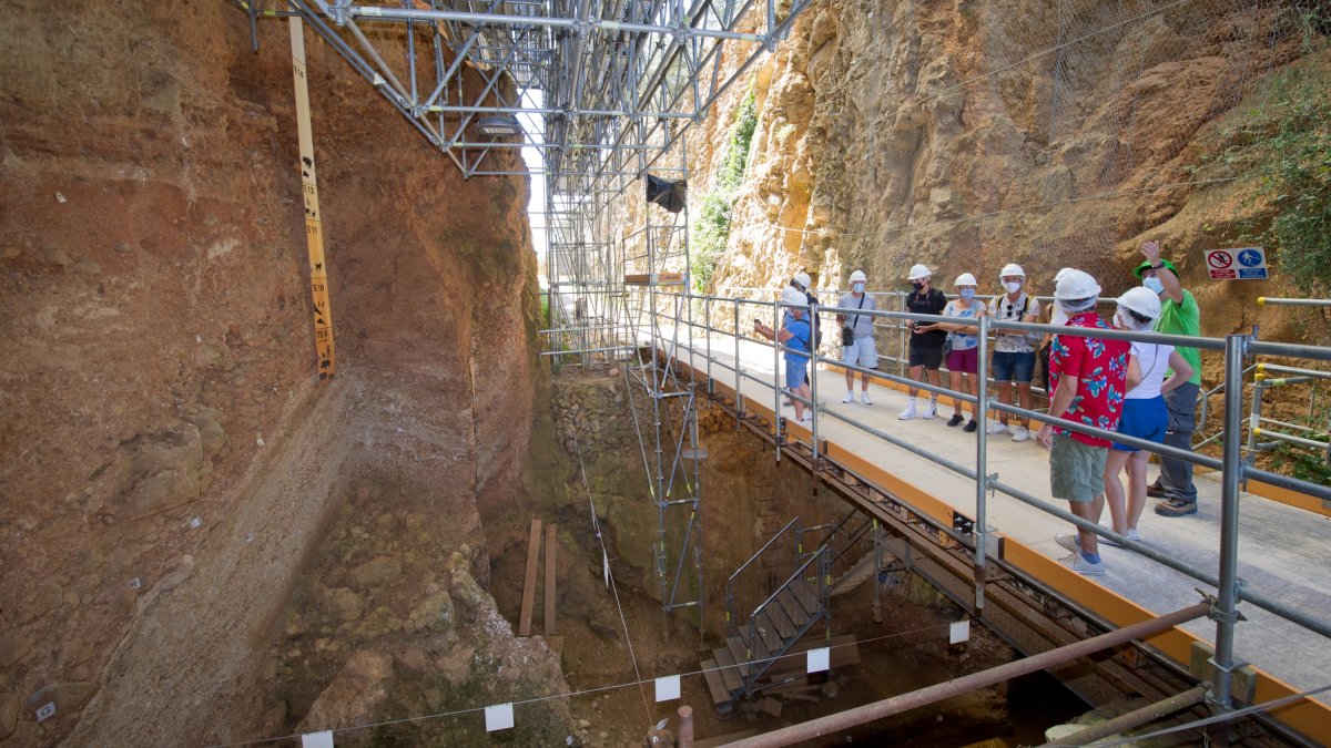 Un grupo de turistas atiende las explicaciones del guía frente al yacimiento de SIma del Elefante en Atapuerca, donde apareció la cara del primer europeo.