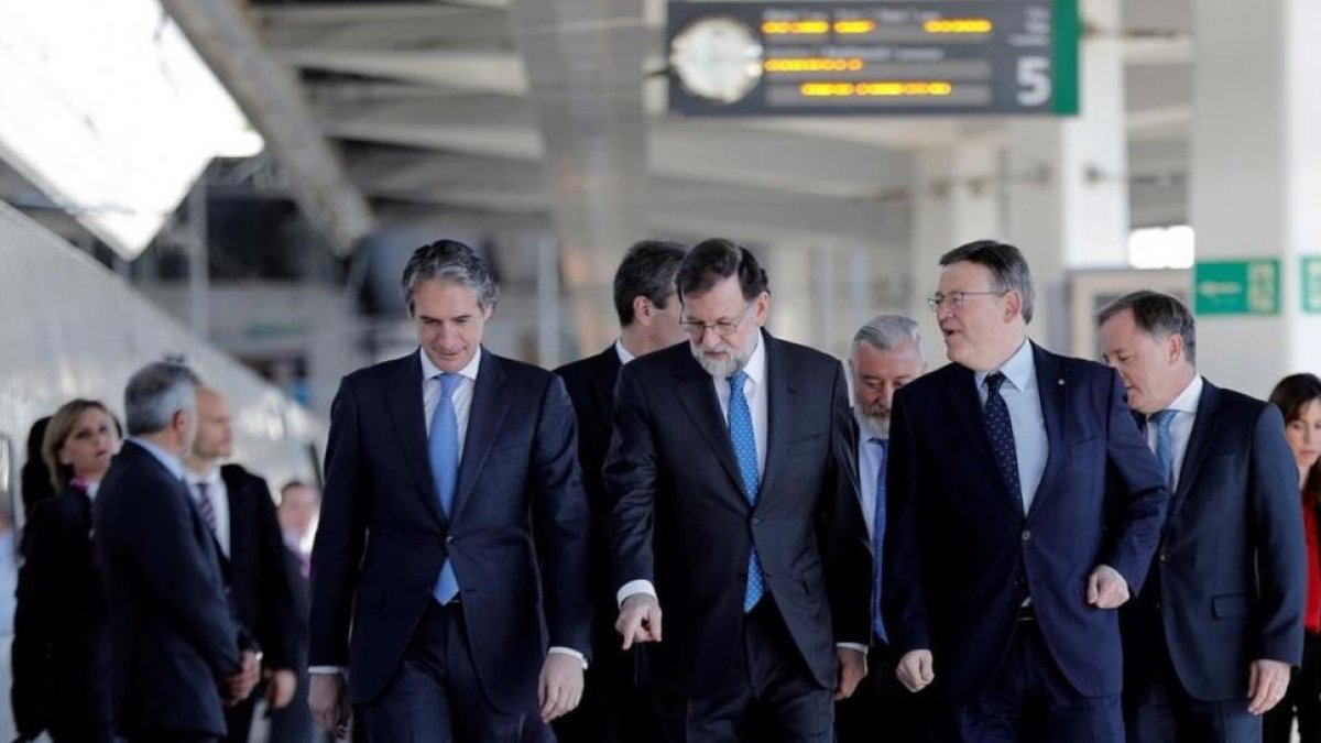 Mariano Rajoy, entre el ministro de Fomento, Íñigo de la Serna (izquierda en la foto), y el presidente de la Comunitat Valenciana, Ximo Puig, en la estación Joaquín Sorolla de Valencia antes de la salida hacia Castellón.-EFE