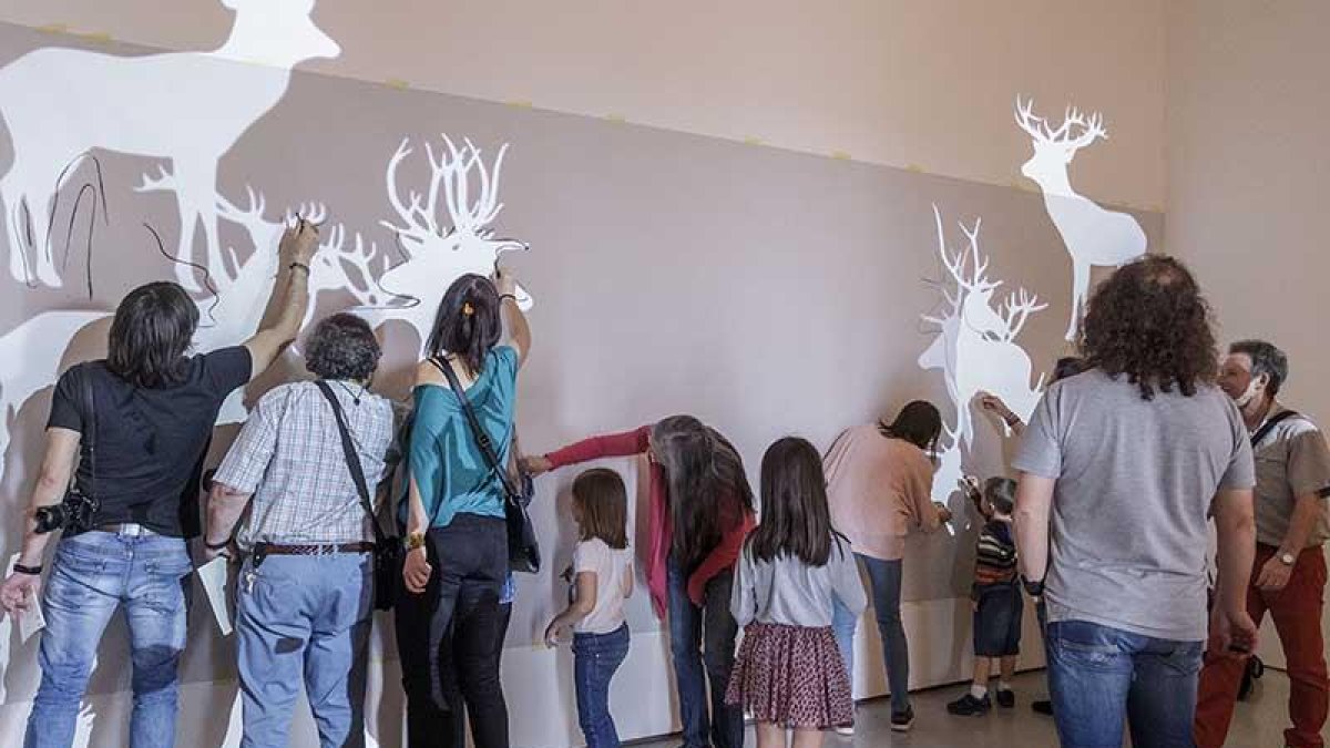 Pequeños y grandes, a la caza de los ciervos de Javier Riera con pinturas sin saber que después se los comerían.-Santi Otero