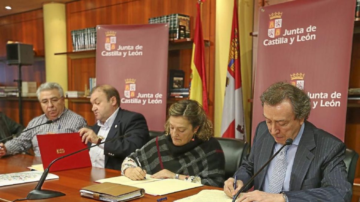 El consejero de la Presidencia, en primer término, estampa su firma en el acuerdo. A su derecha, Carmen Ámez (UGT) y Carlos Hernando (CSIF).-Ical