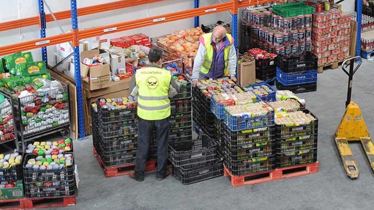 Dos voluntarios en las instalaciones del Banco de Alimentos de la capital en la carretera Madrid-Irún.-ISRAEL L. MURILLO