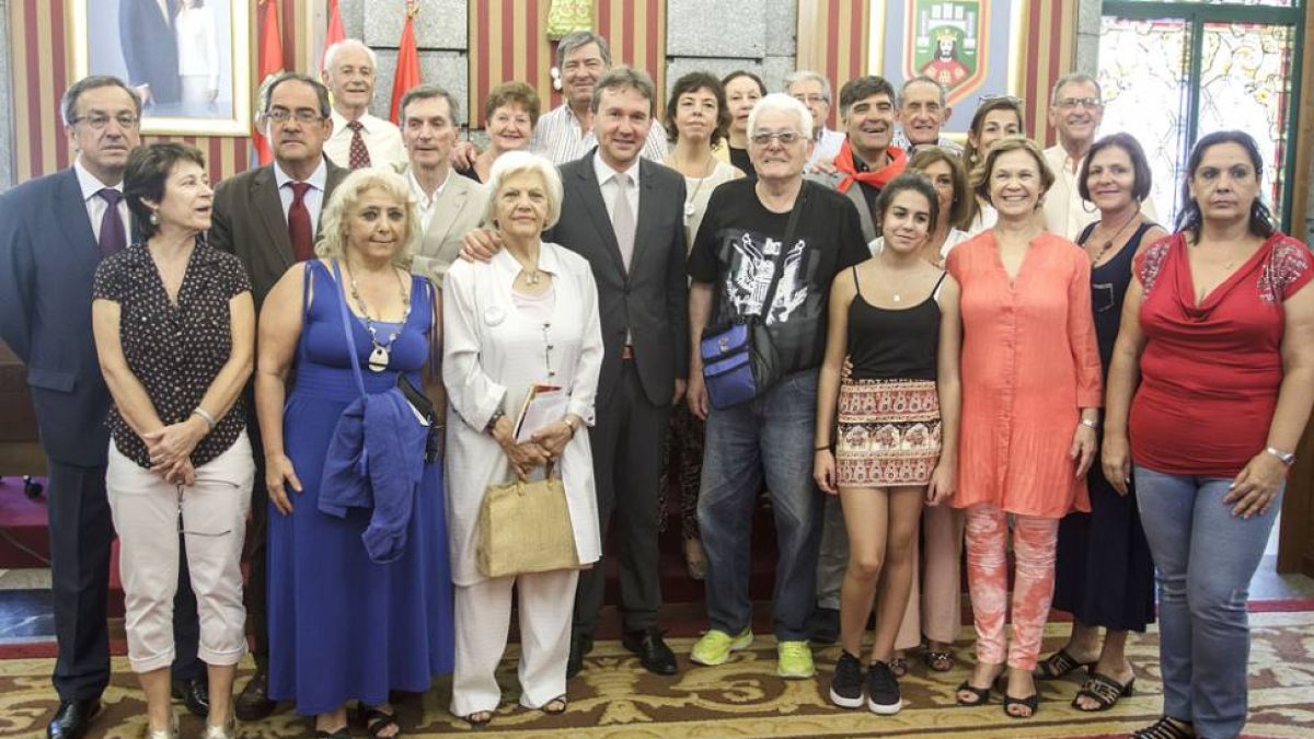 Foto de familia de los emigrantes retornados a la ciudad junto con las autoridades que les recibieron en el Salón de Plenos del Ayuntamiento.-SANTI OTERO