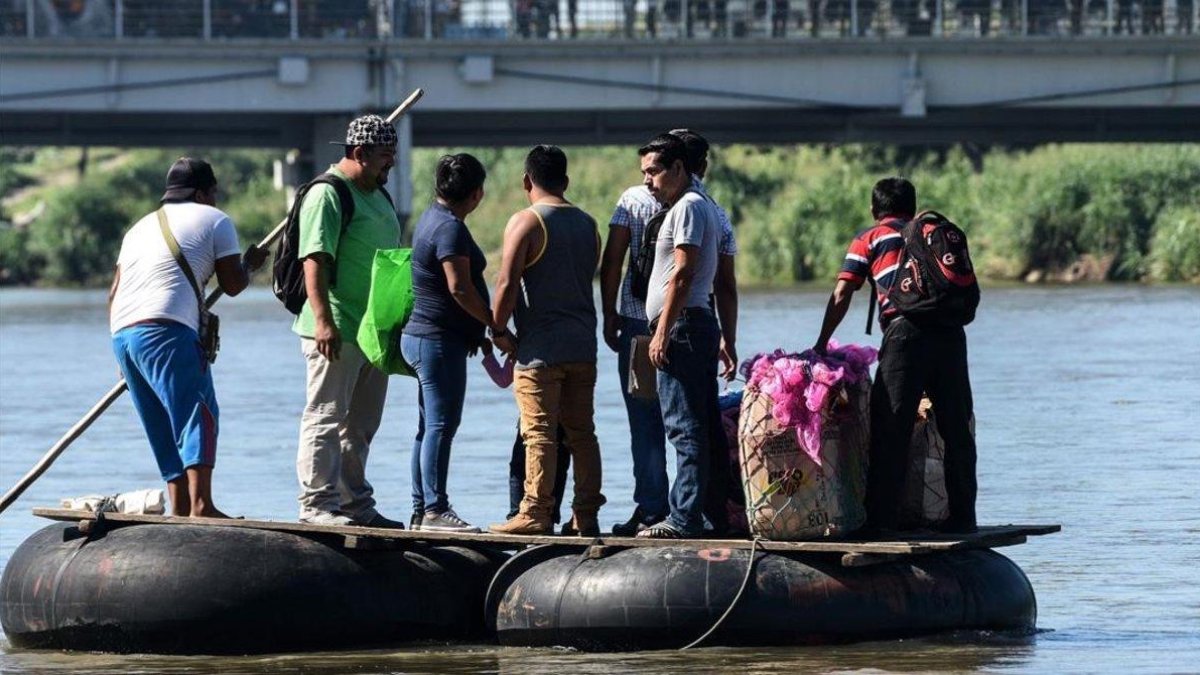 Un grupo de inmigrantes cruza el río Suchiate en unos neumáticos.-ORLANDO SIERRA / AFO