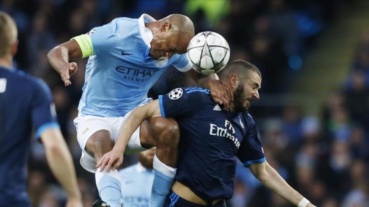 Benzema disputa un balón ante Kompay en el encuentro ante el Manchester City.-REUTERS / PHIL NOBLE