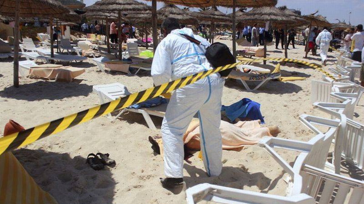 Un policía examina a dos víctimas del ataque terrorista en uno de los hoteles de Susa, en Túnez, el pasado 26 de junio.-Foto: STR / EFE