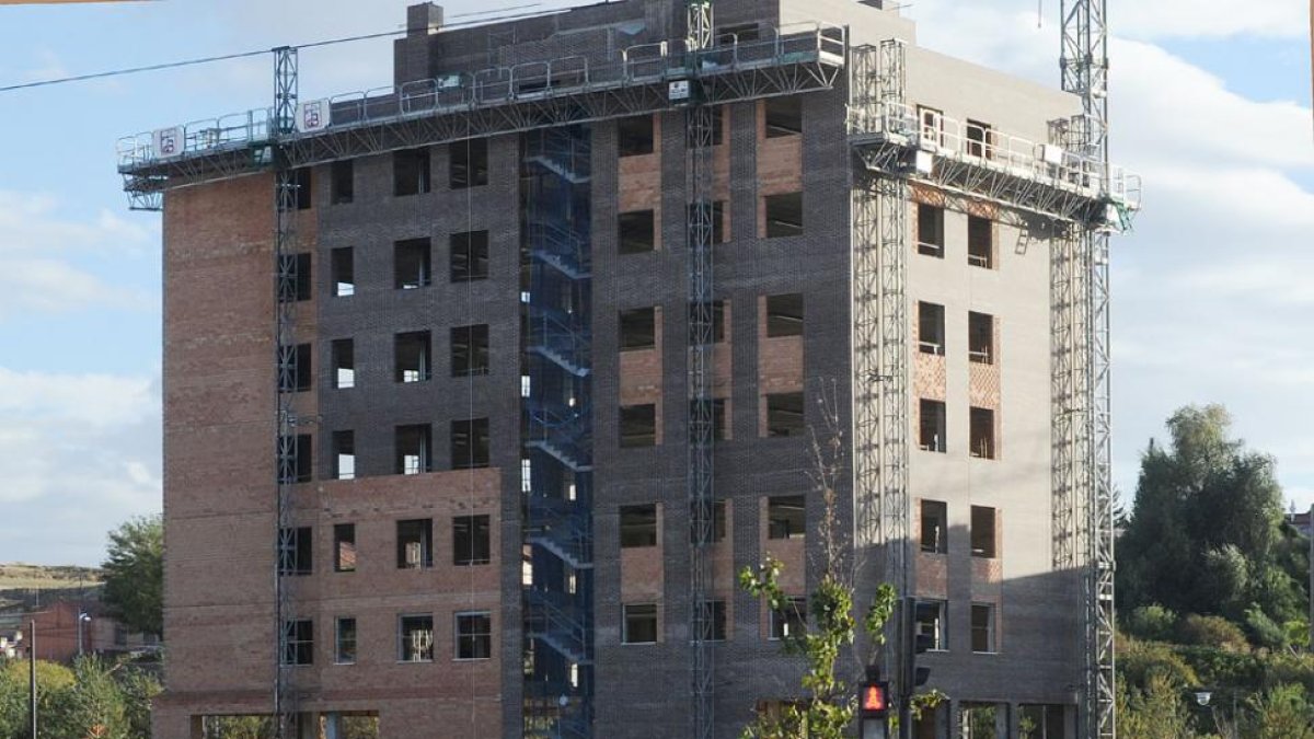 Una mujer y un niño pasan por delante de un edificio en obras.-ISRAEL L. MURILLO