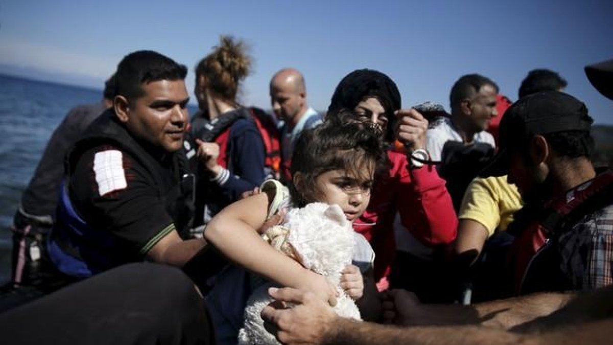 Una niña siria es ayudada a bajar de su embarcación en la isla griega de Lesbos, este sábado.-LKIS KONSTANTINIDIS