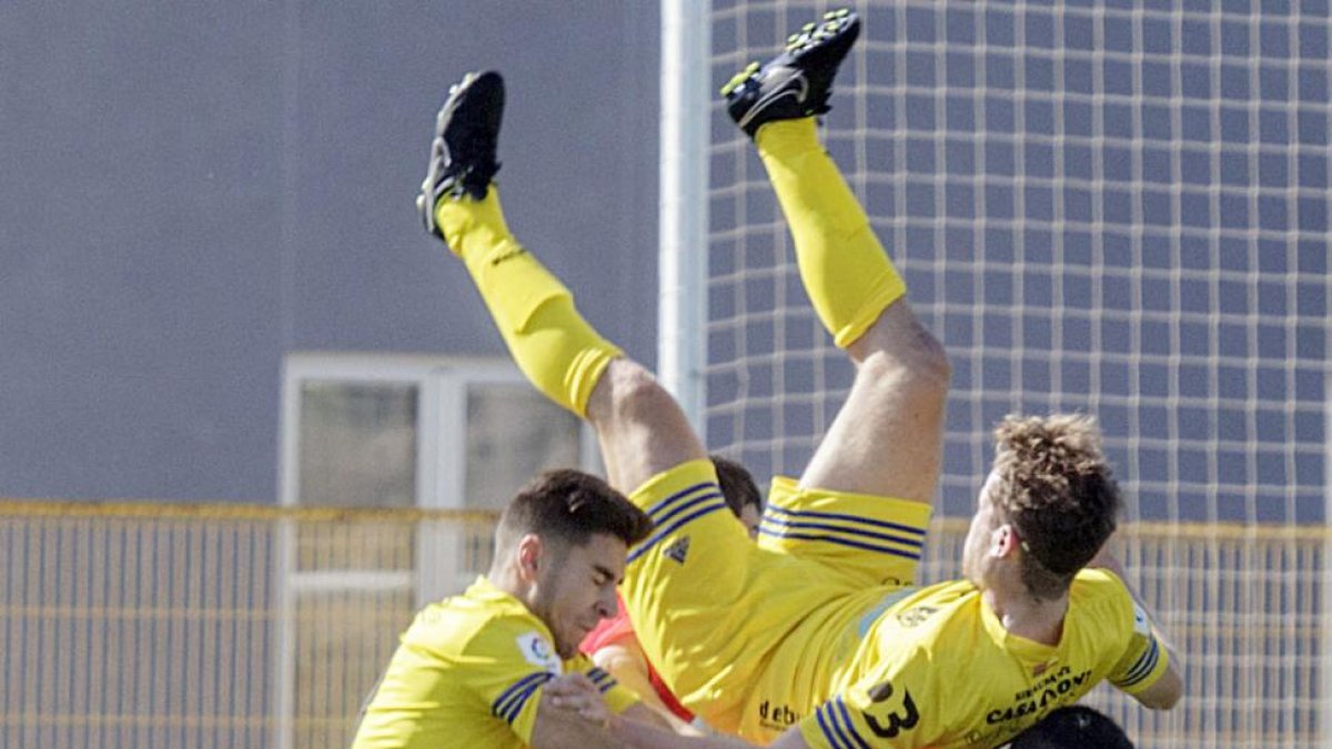 El jugador del Atrio Germán Marijuán cae sobre el defensa delRealBurgos Javier Junyent, ayer, en San Amaro.-SANTI OTERO