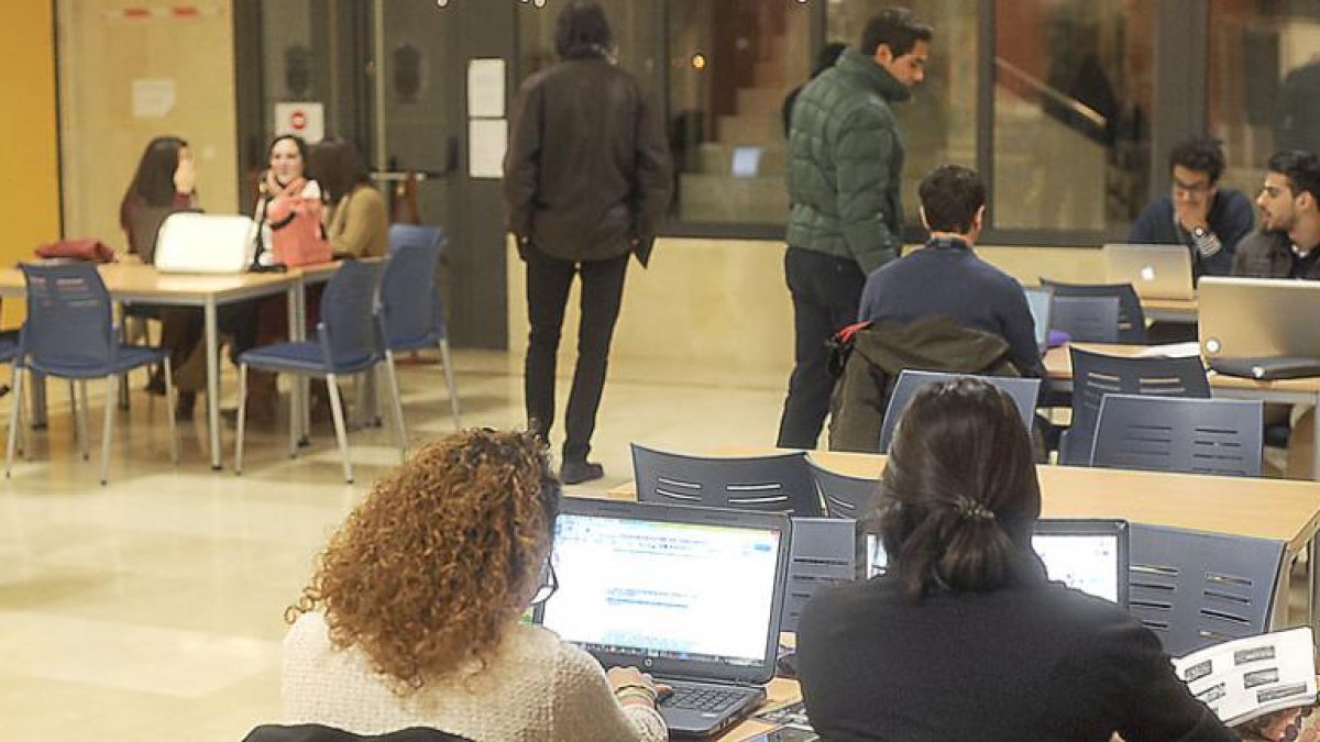 Jóvenes estudiantes con sus ordenadores portátiles en la biblioteca de la Universidad de Burgos.-ISRAEL L. MURILLO