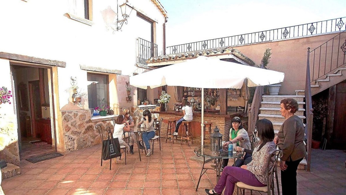 Un grupo de viajeros descansa en el patio de un alojamiento de turismo rural.