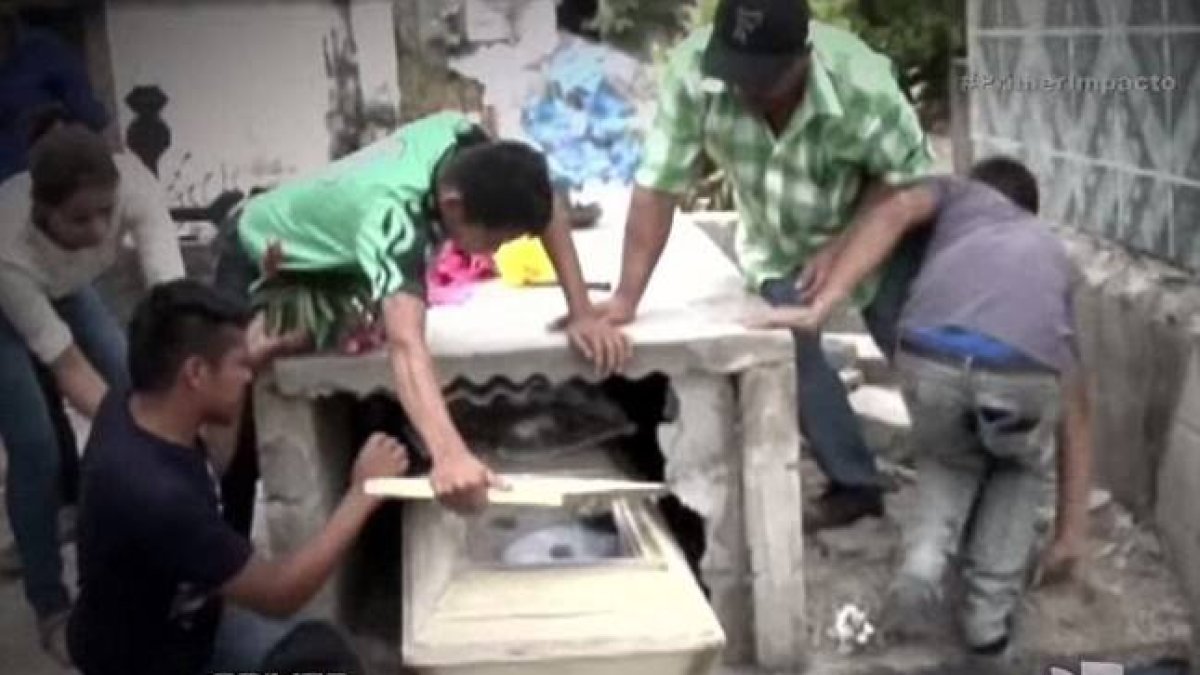 Captura del vídeo en el que se ve a la familia de Neysi Pérez rompiendo la tumba de la joven después de que su marido alertara de había escuchado gritos que provenían del interior.-PRIMER IMPACTO / HONDURAS