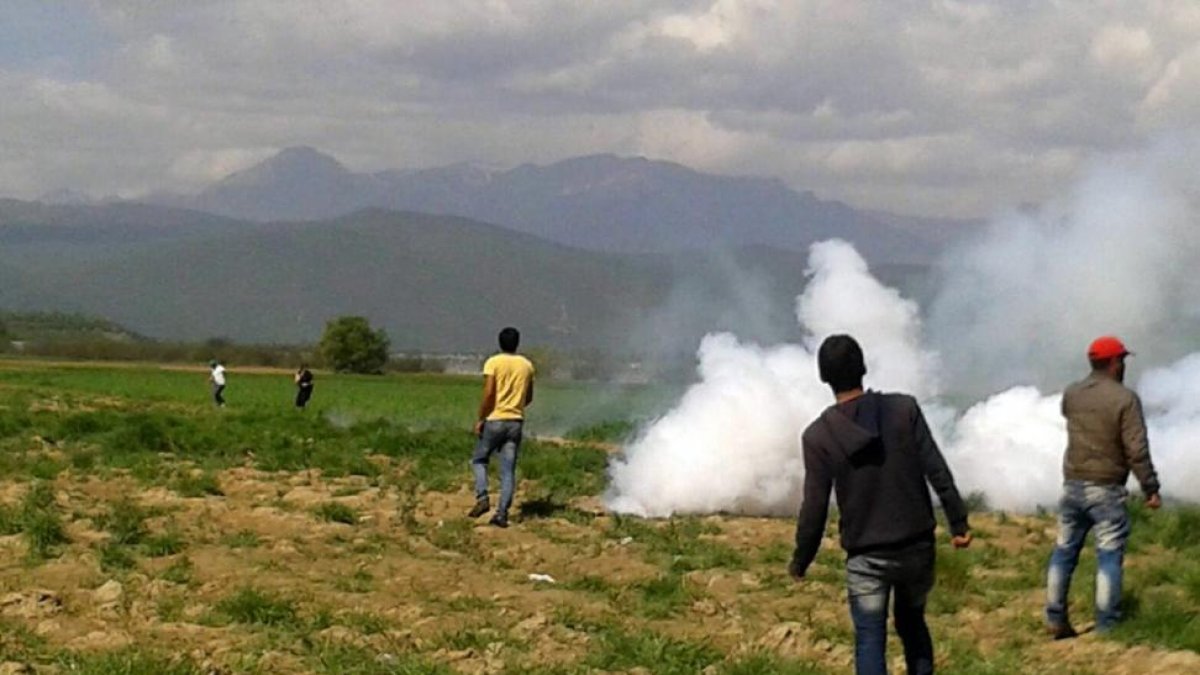 La guardia fronteriza macedonia lanza gases lacrimógenos contra los refugiados que intentaban cruzar la frontera desde Idomeni, este domingo.-EFE
