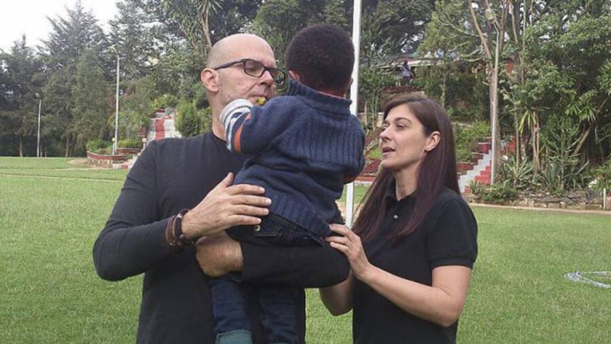 Una pareja sostiene en brazos a su hijo adoptivo, en una imagen de archivo.-EL MUNDO