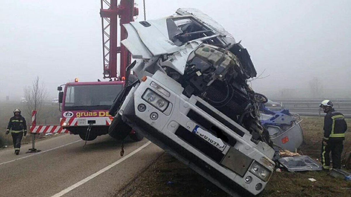 Una grúa trabaja en la retirada del camión siniestrado en la A-231 a la altura de Las Quintanillas.-PROTECCIÓN CIVIL