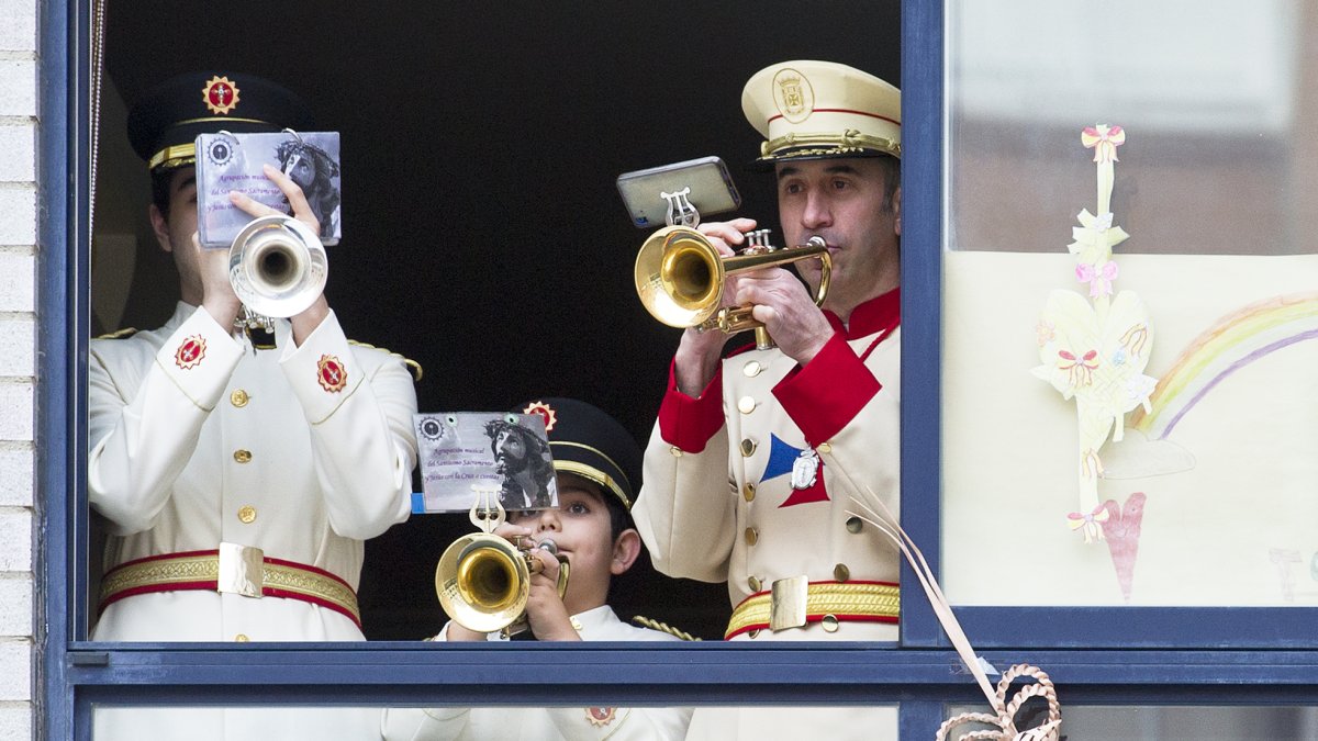 Los tres trompetistas tocan las marchas procesionales desde la ventana. ISRAEL L. MURILLO